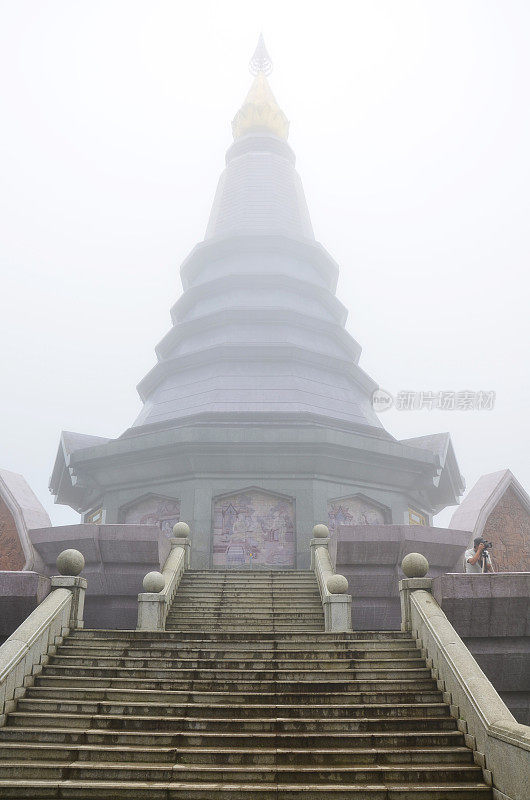 在泰国清迈，泰国游客在Doi Luang或Ang Ga参观时，早上雾雨蒙蒙的印他侬山的Naphamethinidon chedi和naphaphphumisiri宝塔